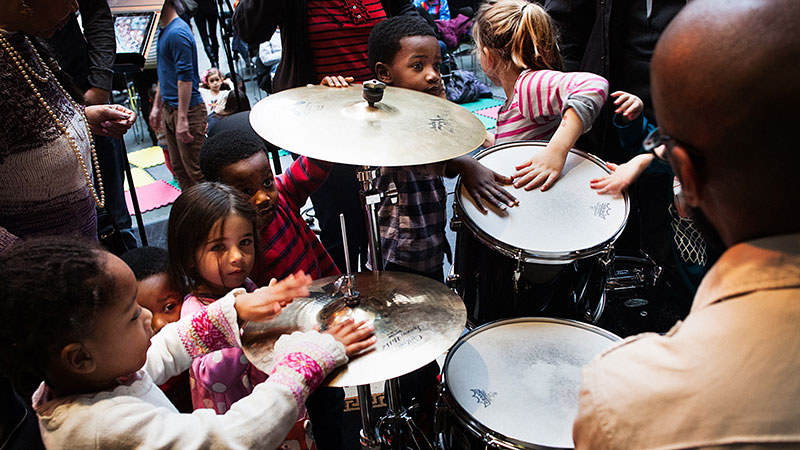 A group of children explore a drum kit at the Kimmel Center
