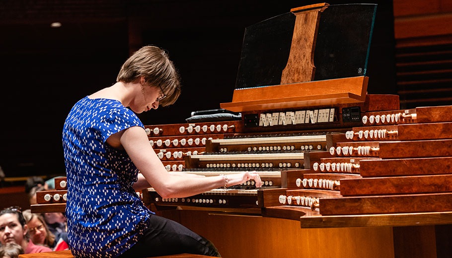 a woman plays the Organ on stage in Verizon hall at the Kimmel Center