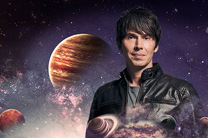 Brian Cox pictured against the background of space and planets