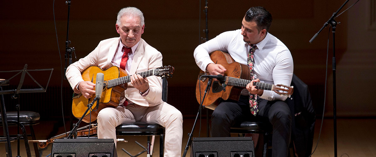 Dorado and Amati Schmitt playing guitar on stage