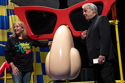 Marc Summers and Robin Russo stand at the pick it game