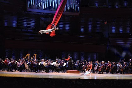 Acrobat performing over orchestra