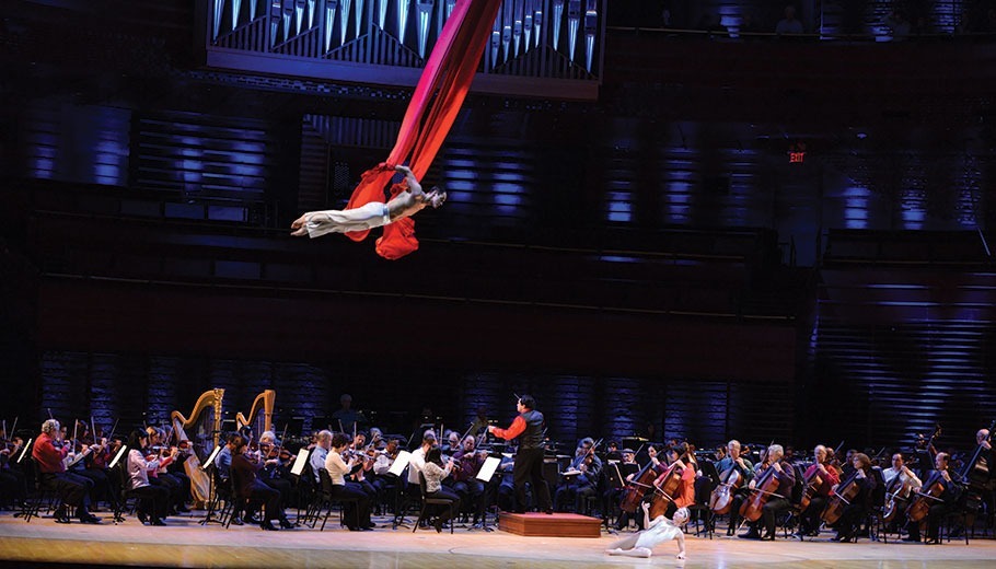Acrobat performing over orchestra