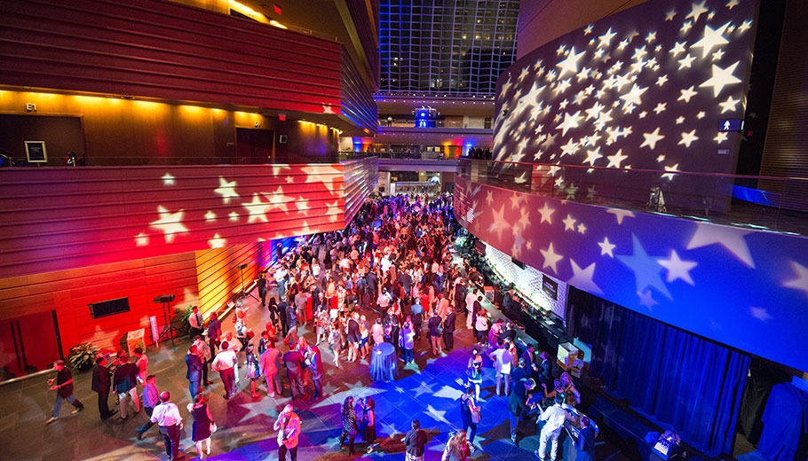 Guests fill the plaza of the Kimmel Center lit up red white and blue with stars