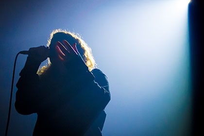 Silhouette of person singing on microphone
