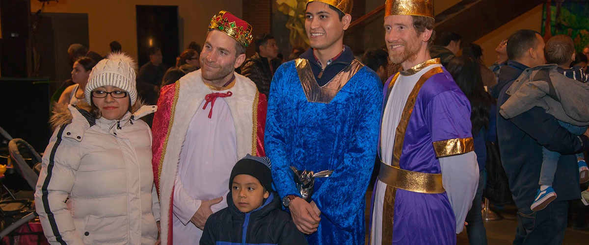 a child poses with the three kings for Three Kings day